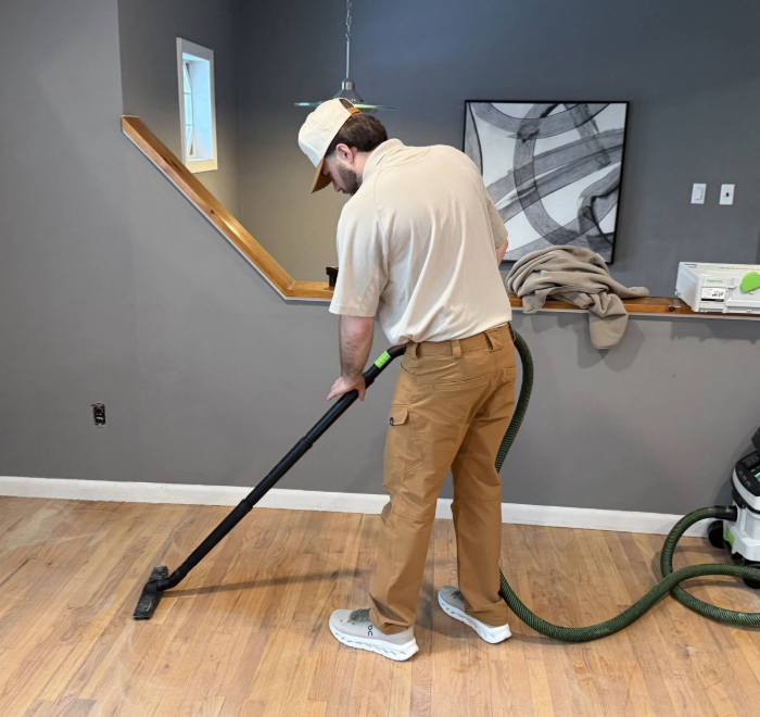 Professional hardwood floor preparation using vacuum before recoating process by North Jersey hardwood floor company