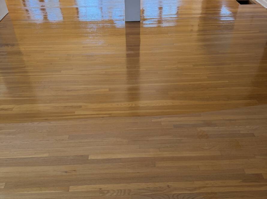 Hardwood floor in New jersey halfway coated by hardwood floor company to show the difference between coated and non coated hardwood